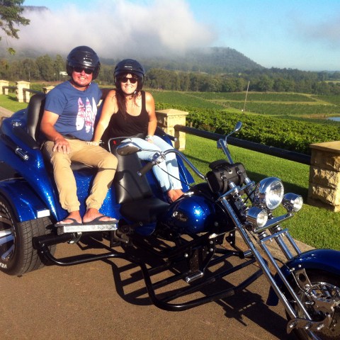 couple riding a bike in vineyard
